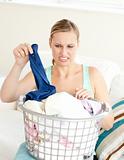 Unhappy woman doing her laundry 