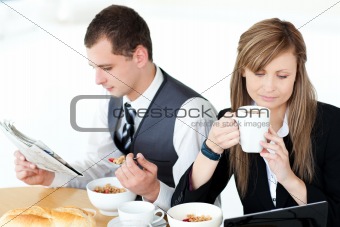 Serious couple of business people having breakfast