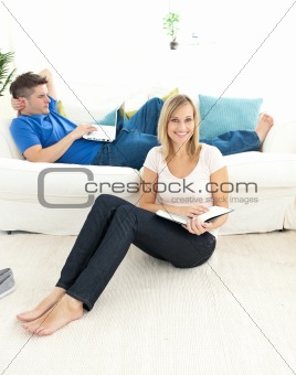 Adorable couple reading book in the living-room at home