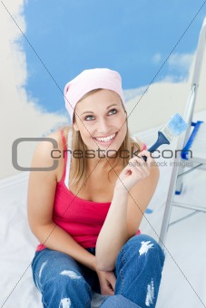 Cheerful woman  painting a room 