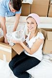 Cheerful couple unpacking boxes after moving