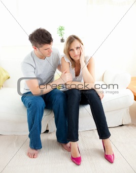 Tired couple having an argue together in the living-room