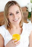Portrait of a smiling woman holding an orange juice 