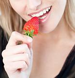 Caucasian woman eating a strawberry 