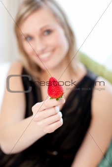 Jolly woman eating a strawberry 