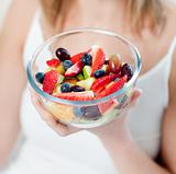 Close-up of a caucasian woman eating a fruit salad 