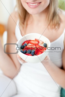 Happy woman eating muesli with fruits 