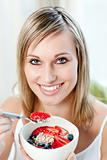 Happy woman eating muesli with fruits