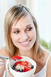 Cheerful woman eating muesli with fruits