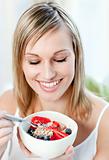 Bright woman eating muesli with fruits 
