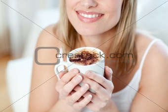 Close-up of a cheerful woman drinking a coffee