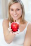 Caucasian woman showing an apple