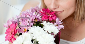 Close-up of a woman smelling a bunch of flowers 