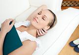 Tired woman sleeping while reading a book 