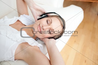 Beautiful woman using headphones on a sofa
