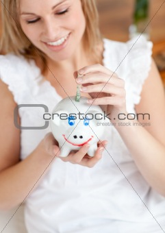 Attractive woman saving money in a piggy-bank