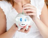 Close-up of a woman saving money in a piggy-bank