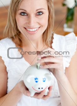 Bright woman saving money in a piggy-bank 