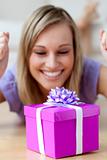Happy woman looking at a gift lying on the floor 