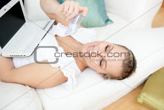 Charming blond woman shopping on-line at home 