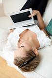 Beautiful young woman surfing the internet lying on a sofa
