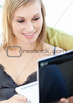Bright woman surfing the internet sitting on a sofa