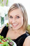 Smiling woman eating a salad 