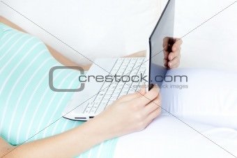 Close-up of a woman surfing the internet lying on a sofa 