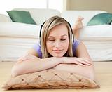 Relaxed woman listening music lying on the floor