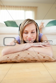 Beautiful woman listening music lying on the floor