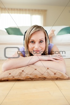Charming woman listening music lying on the floor