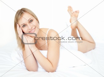 Attractive young woman lying on a bed 