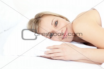 Smiling beautiful woman relaxing on her bed
