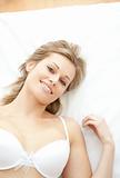 Radiant woman in underwear lying on bed