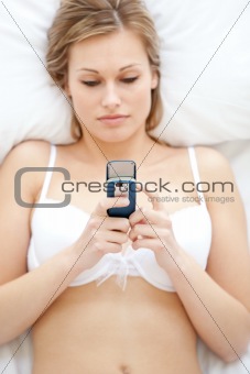 Concentrated woman in underwear sending a text 