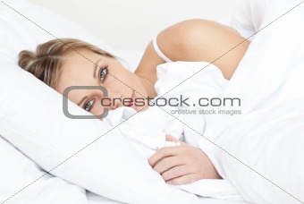 Radiant woman relaxing lying on her bed 