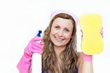 Smiling woman holding a sponge and a detergent spray