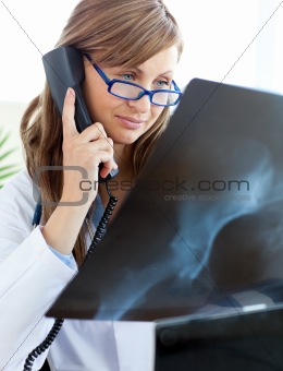 Concentrated female doctor talking on the phone 