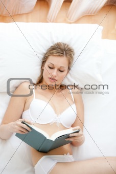 Attractive woman in underwear reading a book