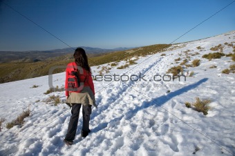 woman with rucksack on snow path