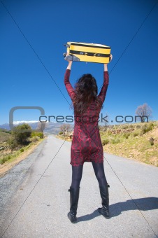 woman with suitcase over head