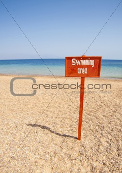 View from a tropical beach with swimming sign