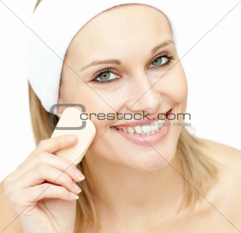 Cheerful woman putting foundation cream