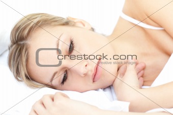 Radiant woman relaxing lying on her bed