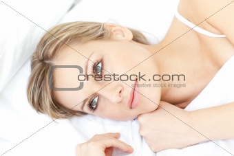 Bright woman relaxing lying on her bed 