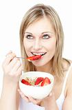 Charming woman eating cereals with strawberries 