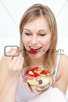 Charming woman eating fruit salad 
