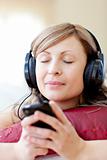 Radiant woman is listening the music in the living-room 