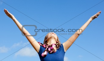 Relaxed  blond woman punching tha air against blue sky