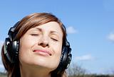 Relaxed woman listenng music outdoors
